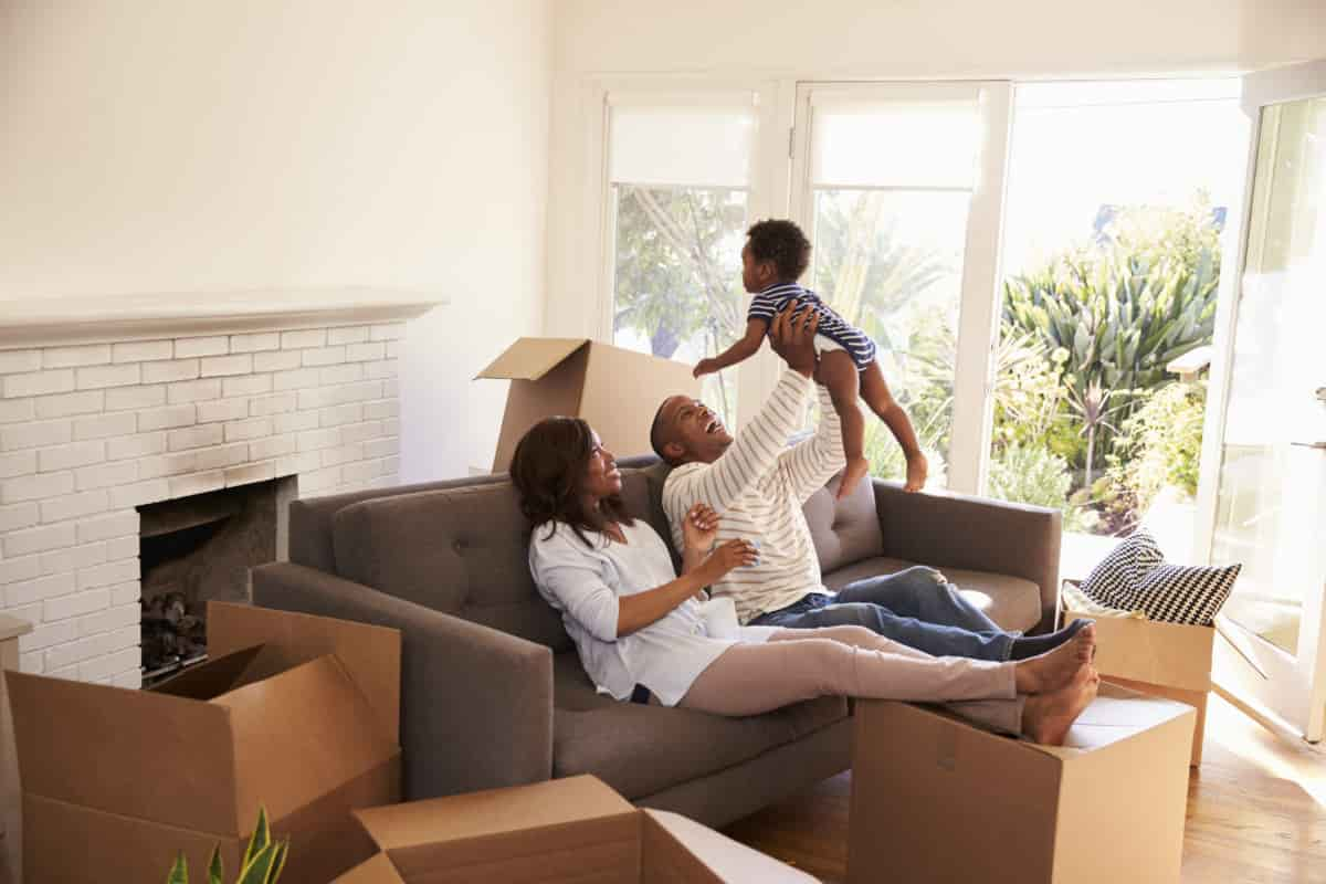 Parents Take A Break On Sofa With Son On Moving Day