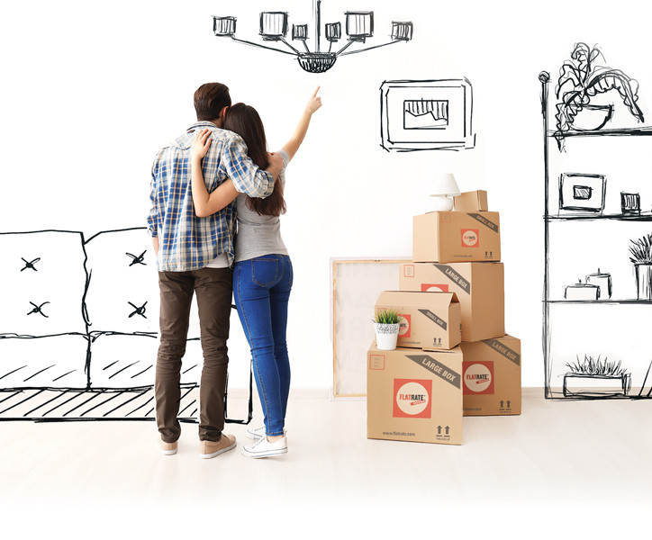 A couple in a lightly furnished room, with FlatRate moving boxes