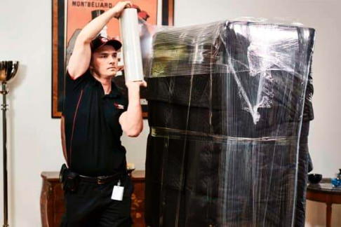A FlatRate mover wrapping a piece of furniture