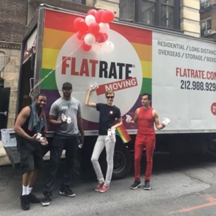 FlatRate movers pose in front of the FlatRate Pride truck