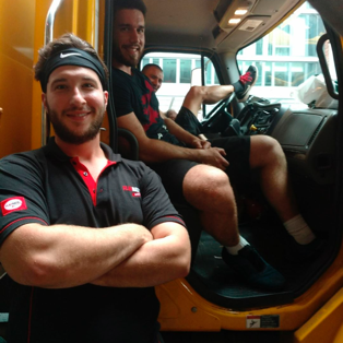 FlatRate movers pose inside their truck