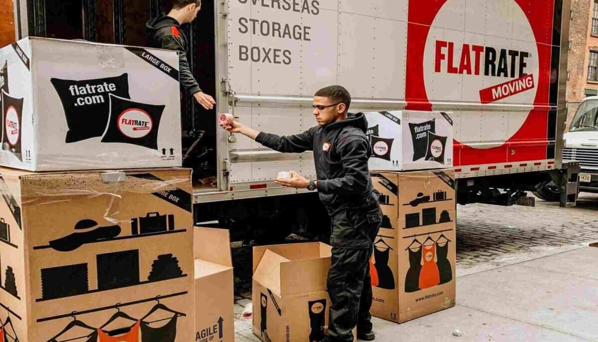 Two Flatrate movers uploading boxes into the truck