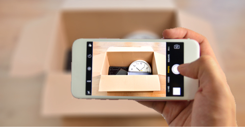 A person takes a picture of their packed box