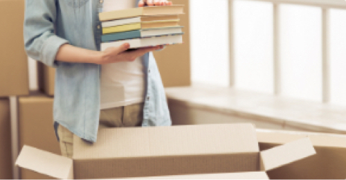 A person packs books into a box