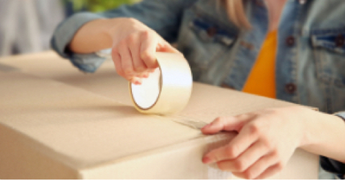 A person tapes a box shut
