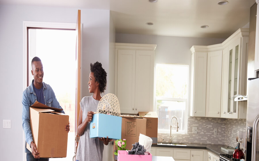 Couple moving boxes into their new home