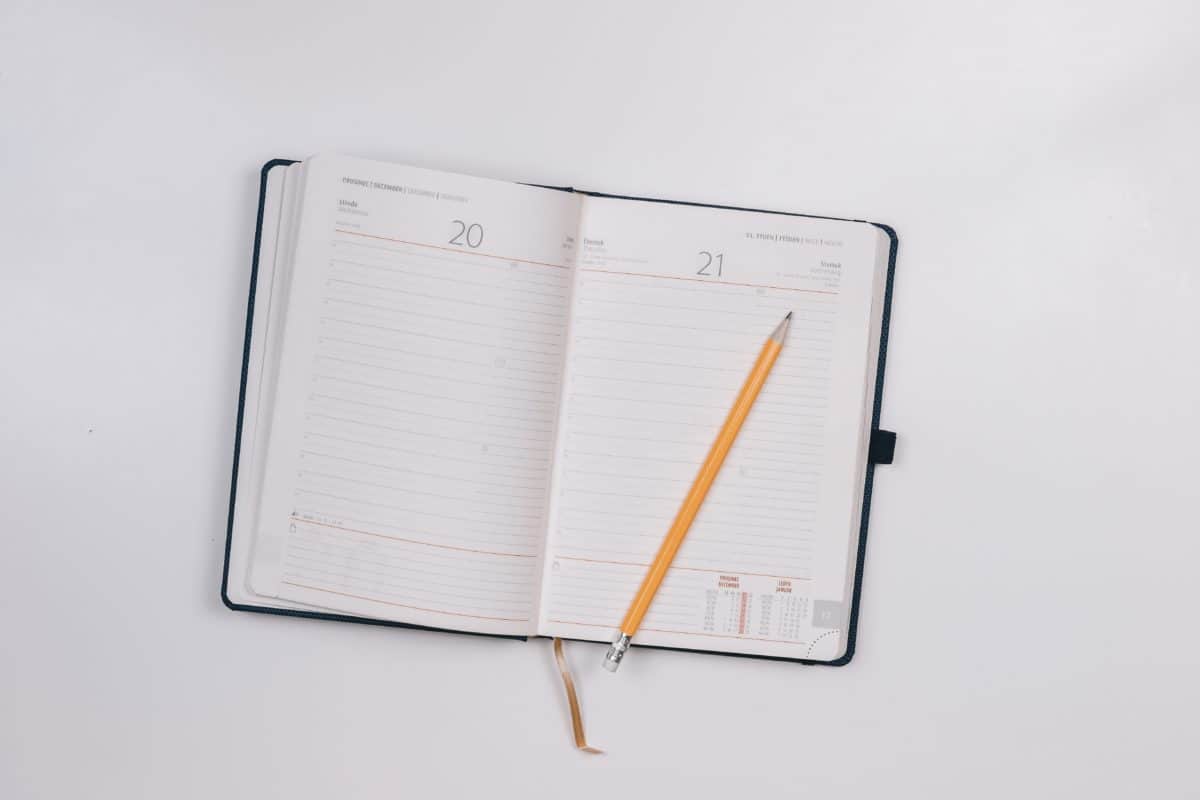 blank calendar book planner with a pencil on top of it
