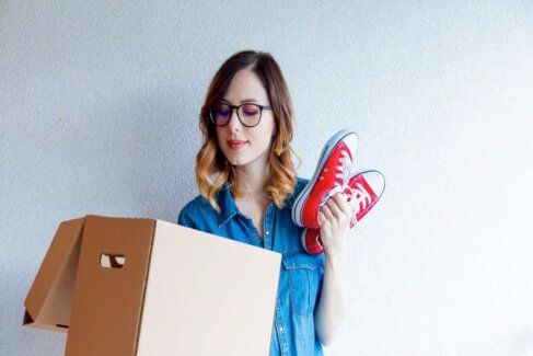 Lady packing red shoes into a box
