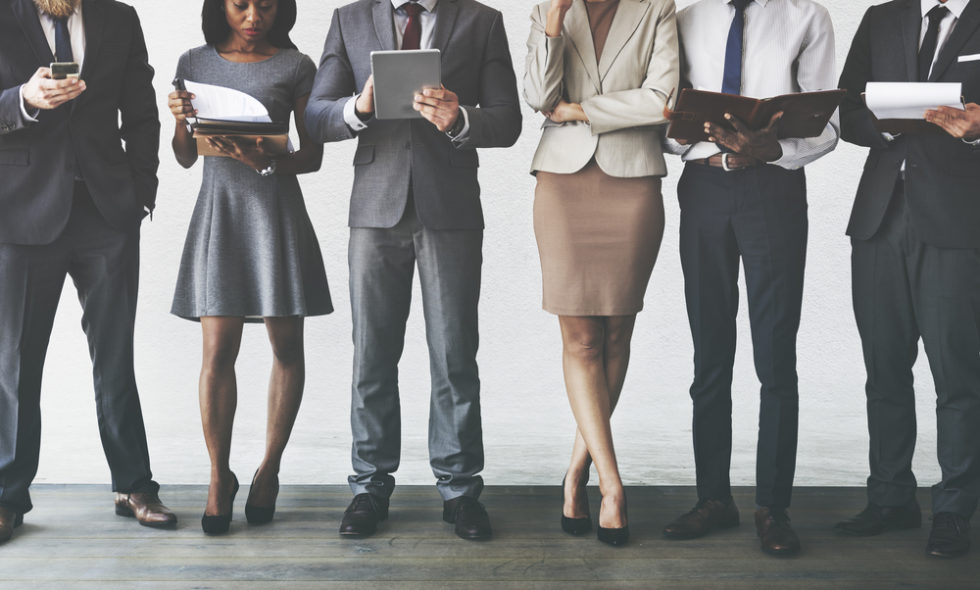 Group of Employees in Business Attire Using Mobile Tablets and Phones