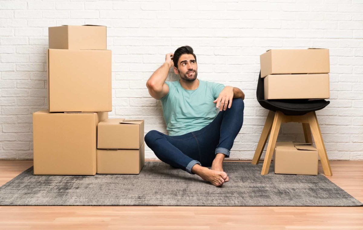 a guy next to a moving boxes