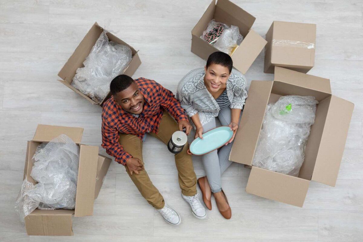 A man and a woman packing kitchet items