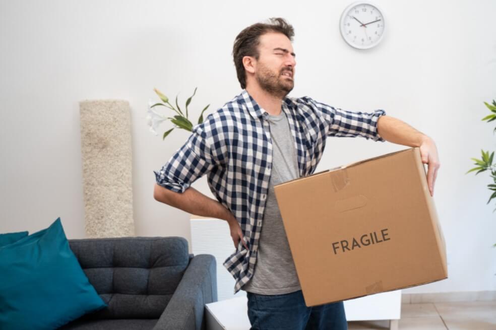 Man moving boxes with back pain