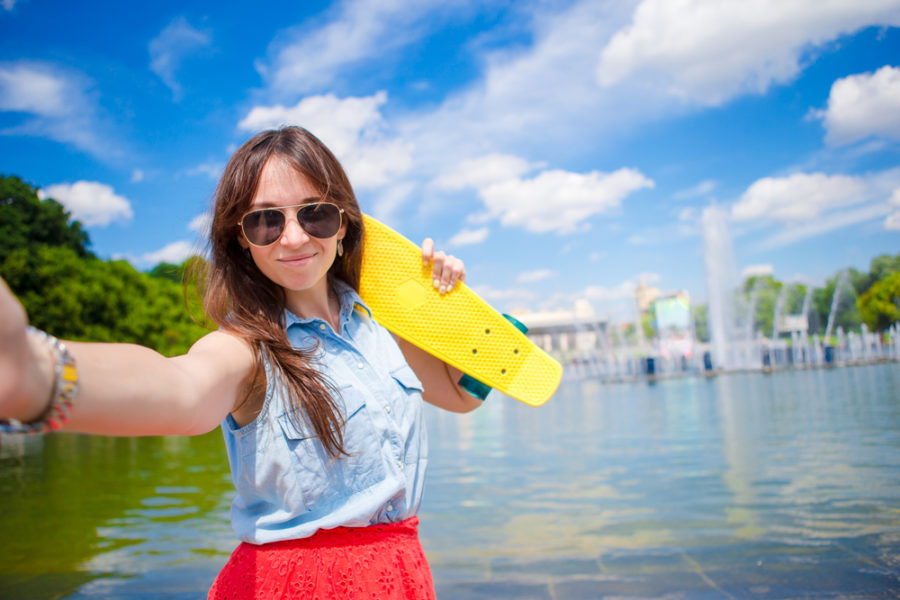 woman in sun with skateboard