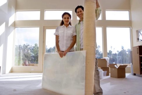 couple with wrapped painting and carpet