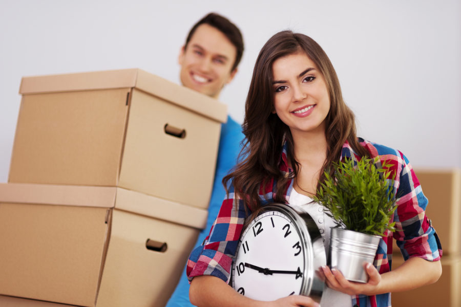 woman and man with boxes and clock