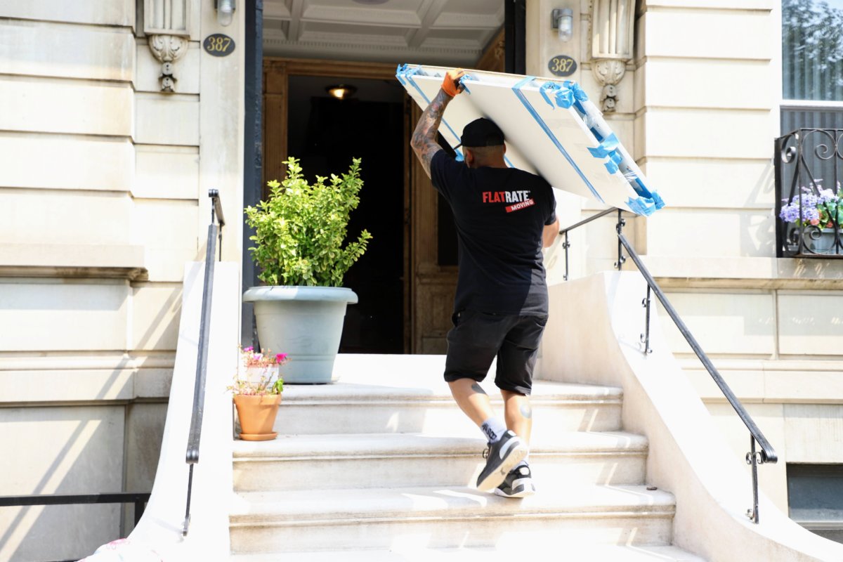 man carrying art into building