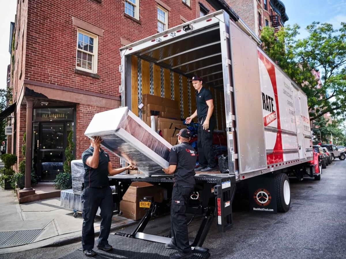 Three Flatrate Movers downloading furnitures from the truck