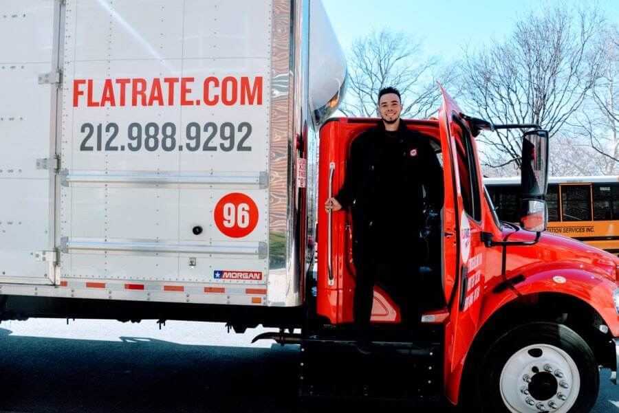 smiling flatrate mover in truck  7 Things that Make a Good Moving Company
