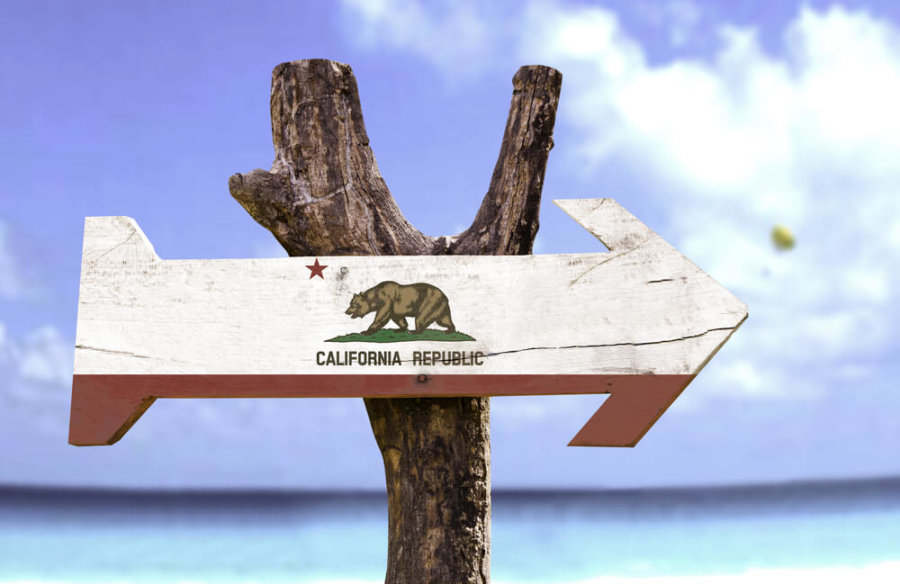 wooden arrow sign painted like california flag