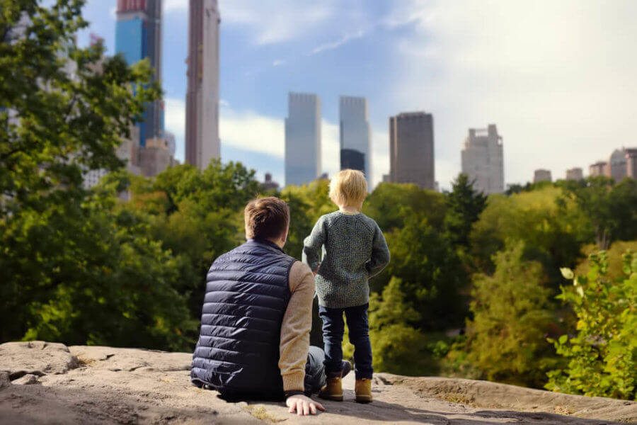 Father and son stand over a rock in the Central Park