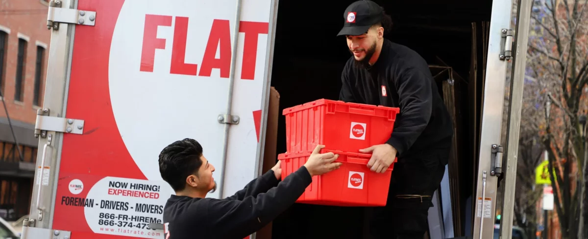 Two Flatrate movers downloading boxes from the truck