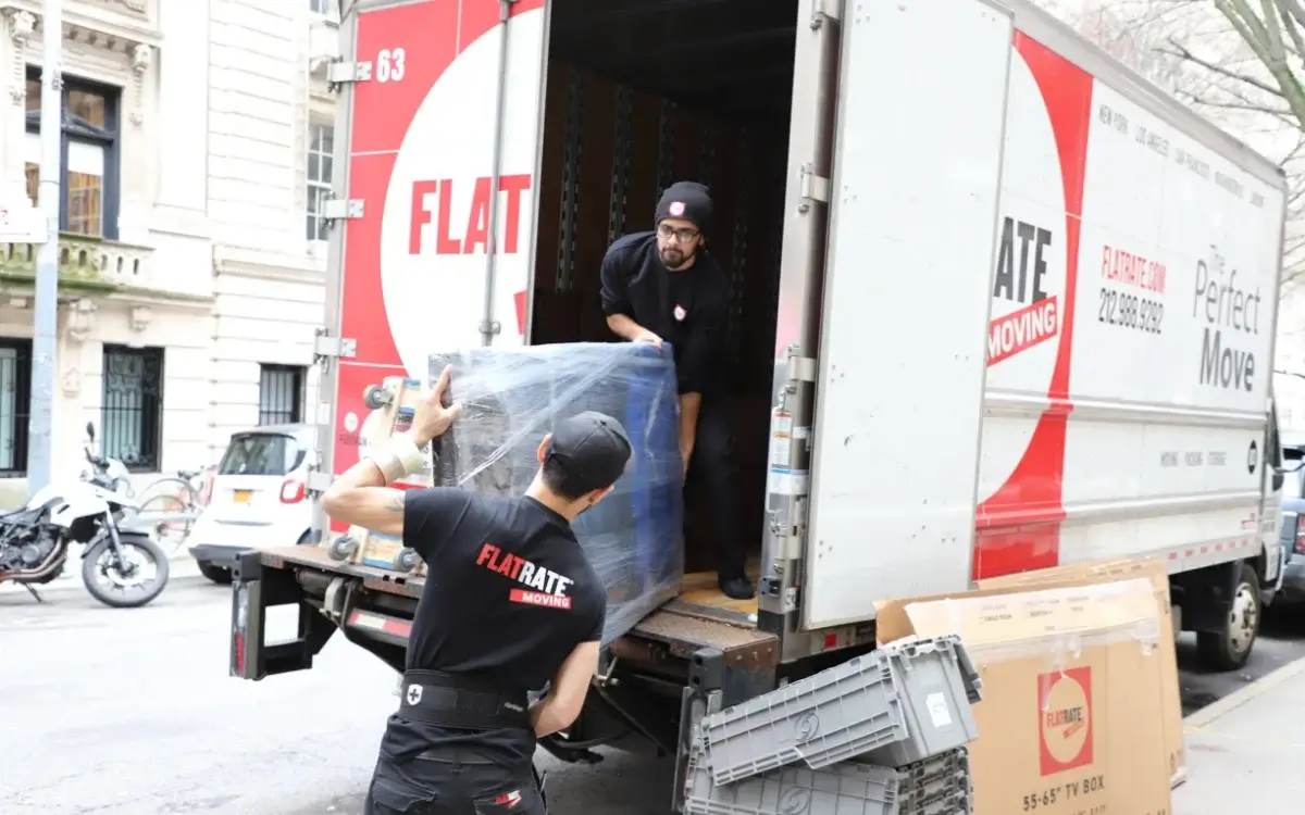 Movers uploading a box to the truck
