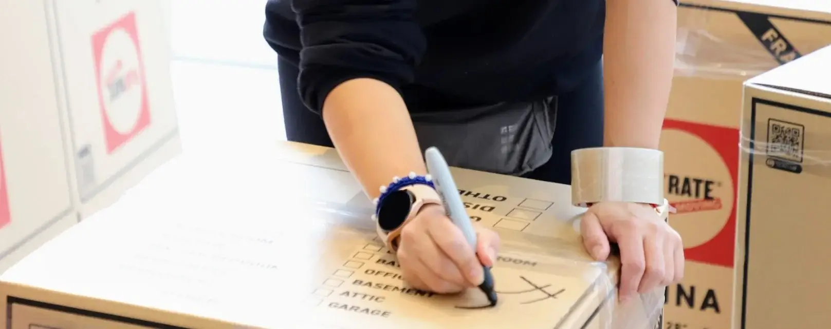 two hands labaling a moving box