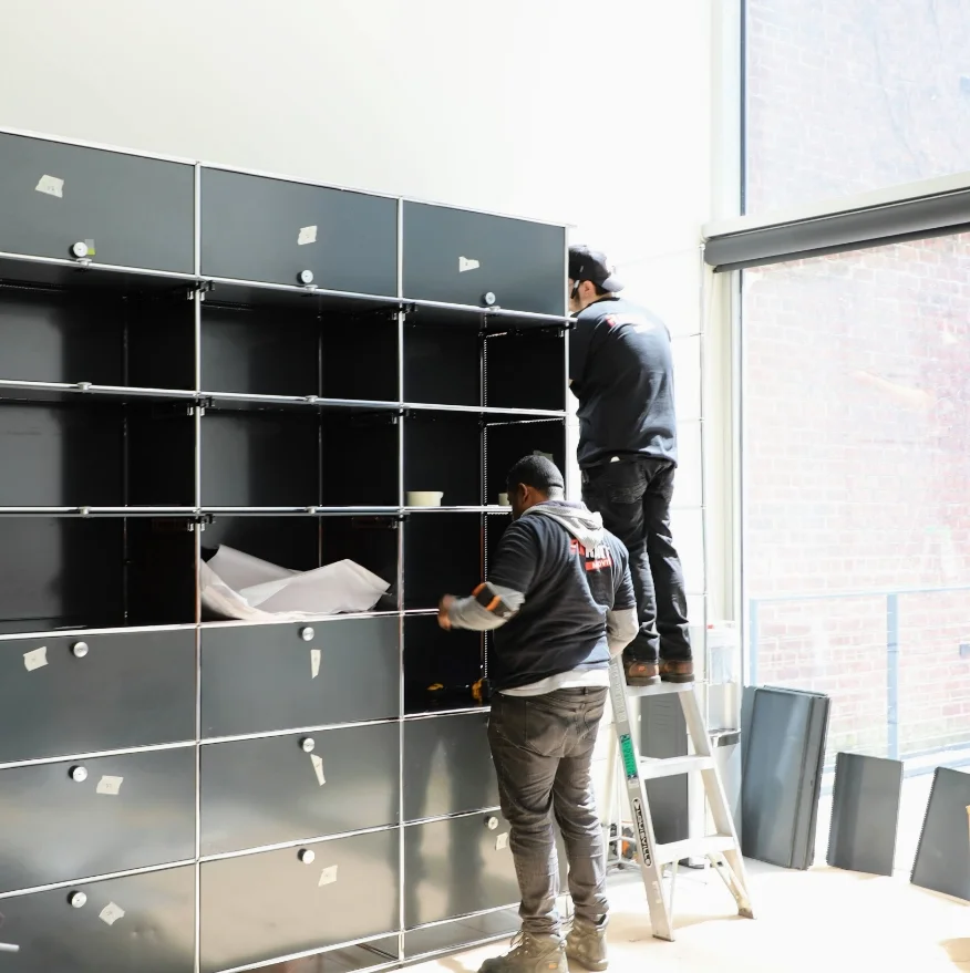 Two movers working on furniture instalation