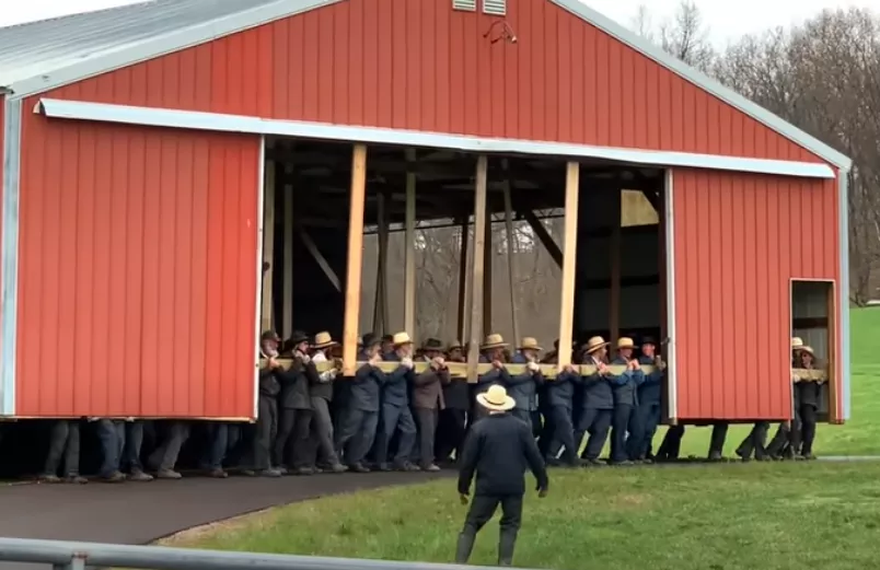 Amish people moving a building