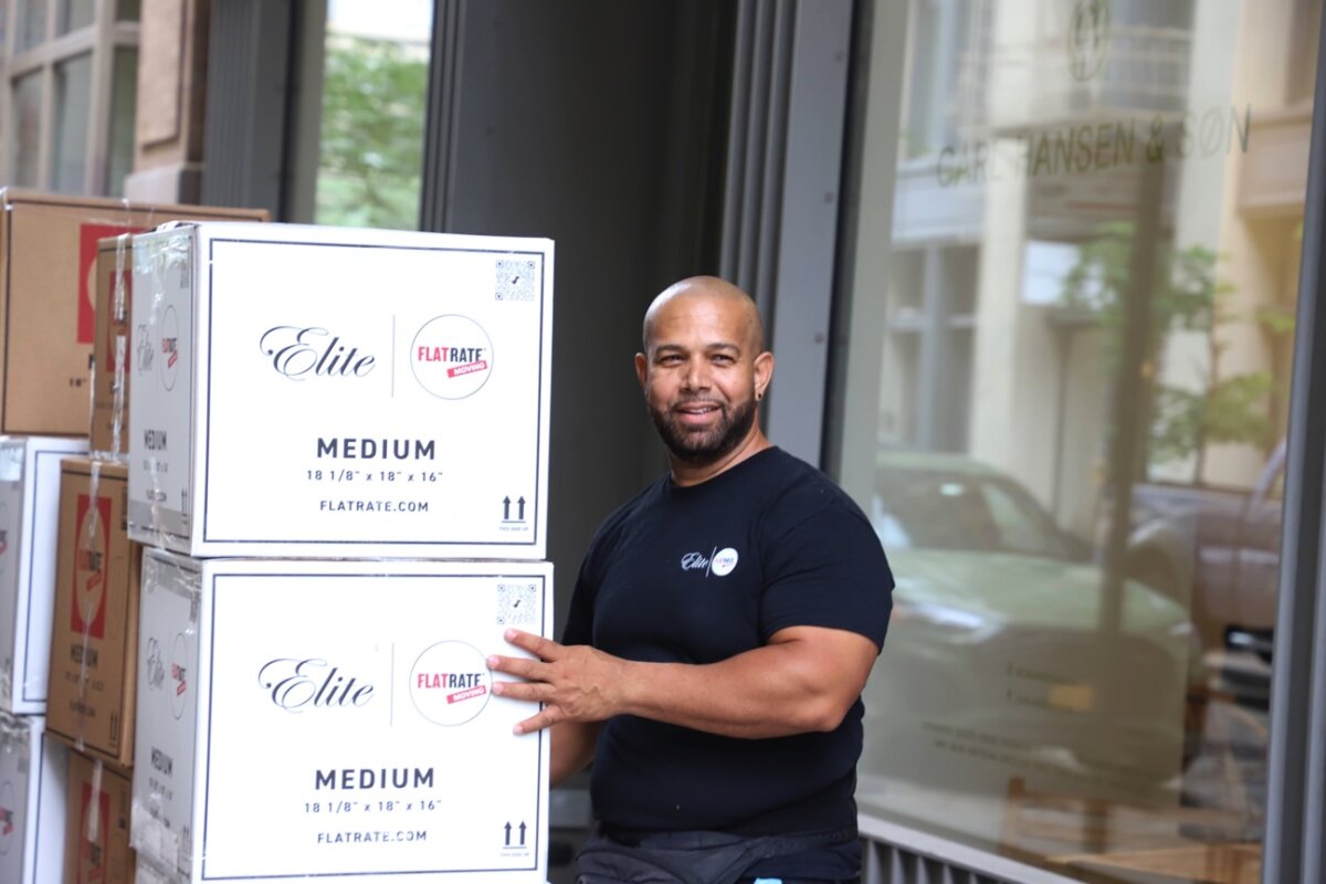 Flatrate mover standing next to a moving box