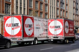 Two flatrate moving trucks 300x200 The Hidden Costs of Moving: What Some Moving Companies Charge