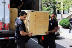 flatrate movers carrying a custom wooden crate 300x200 Elevating Employee Experience During Corporate Move