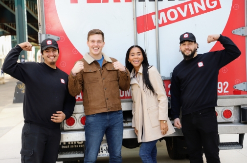 Movers posing with smiling and satisfied clients after successful relocation