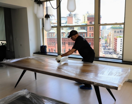 Man wraping a table to protect it