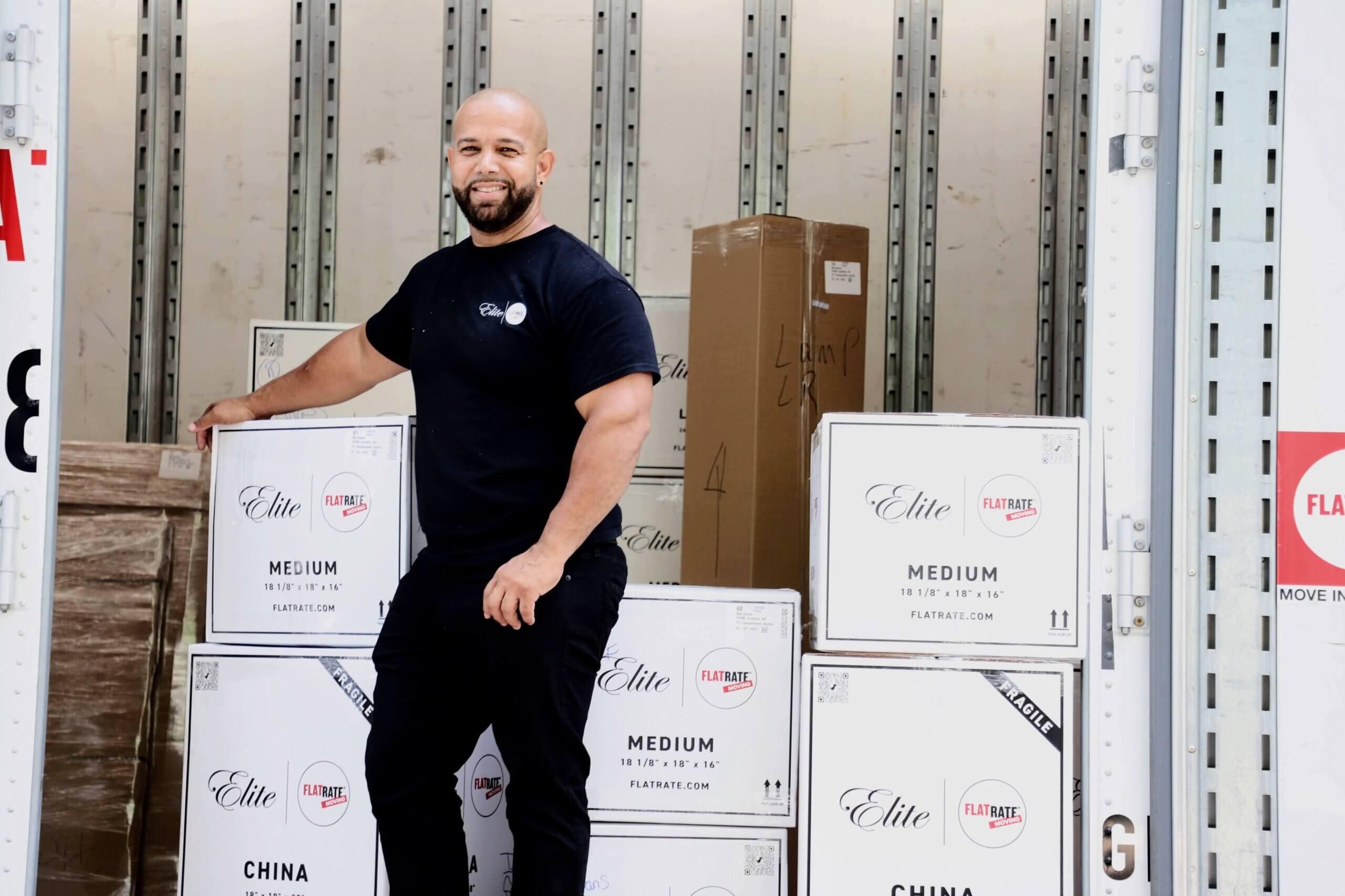 Mover posing into the truck rounded by moving boxes