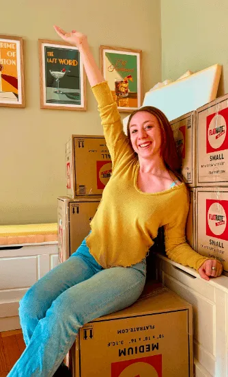 Happy lady sitting on Flatrate boxes